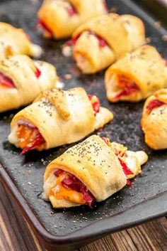 small pastries with meat and cheese are on a baking sheet, ready to be eaten