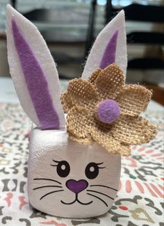 a close up of a small vase on a table with a bunny's head