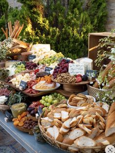 a table filled with lots of different types of breads and cheeses on it