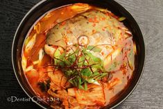 a bowl filled with meat and vegetables on top of a table