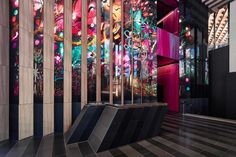 an artisticly designed building with colorful glass panels on the wall and floor, in front of a staircase