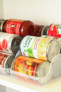 several cans of canned food are stacked on top of each other in an organized bin