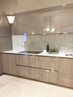 an empty kitchen with marble counter tops and white tile flooring on the side wall