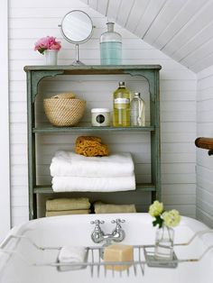 a white bath tub sitting next to a shelf filled with towels