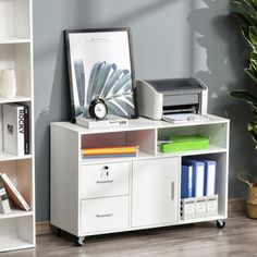 a white desk with a printer and other office supplies on it, next to a bookshelf