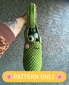 a hand holding a green crocheted bag with a face on it and the words pattern only