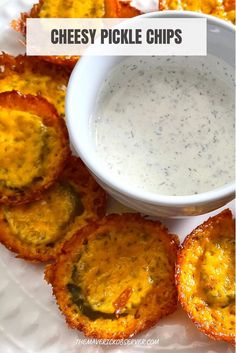 cheesy pickle chips on a white plate with dip in the middle and small bowl next to them