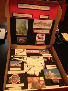 an open box with pictures and magnets in it on top of a black table