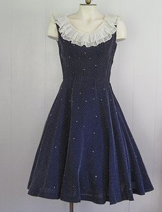 APPROXIMATE MEASUREMENTS (INCHES): Current Size: S Bust: 34 Waist: 25 Hip: Open Bodice (shoulder to waist): 16 Skirt (waist to hem): 28 CONDITION Excellent DESCRIPTION 1950s fit & flare dress Lightweight navy blue and white Swiss dot fabric Lined/built in slip Pleated/ruffled neckline Rhinestone embellished Full Skirt 1950s Style Polka Dot Party Dresses, Polka Dot 1950s Style Party Dress, 1950s Style Sleeveless Polka Dot Dress, 1950s Style Polka Dot Sleeveless Dress, 1950s Sleeveless Vintage Party Dress, 1950s Style Sleeveless Vintage Party Dress, Sleeveless Ruffled Dress For Vintage Events, Sleeveless Ruffled Vintage Dress For Evening, 1950s Sleeveless Dress For Vintage Events