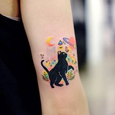 a black cat tattoo on the left inner arm and wrist, with stars in the background