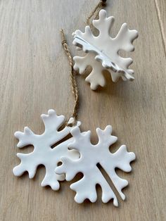 two white snowflake ornaments on a wooden table