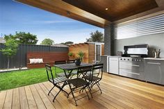 an outdoor kitchen and dining area with wood flooring