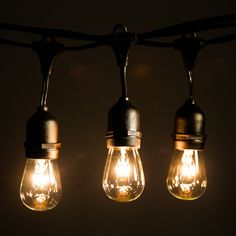 three light bulbs are hanging from a wire with lights on them and one is turned on