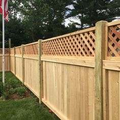 a wooden fence in the grass with an american flag