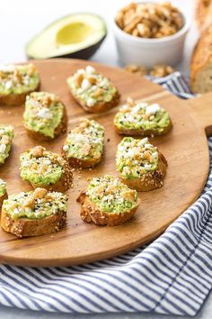 small appetizers are arranged on a wooden platter