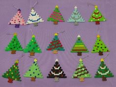 a bunch of small christmas trees made out of perler beads on a purple background