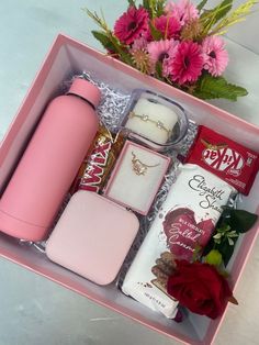 a pink box filled with lots of different types of items next to a red rose