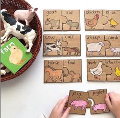 a child's hands playing with farm animals and words on wooden puzzles in front of a basket