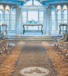 the aisle is lined with candles and flowers in front of an open window at disney's fairy tale wedding