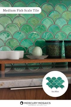 a kitchen with green tiles and white dishes on the counter, along with sea mist