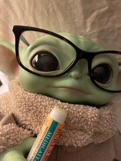 a baby yoda doll with glasses and a tube of toothpaste on it