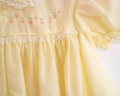 A sweet frock for a sweet little girl. This bright and cheery yellow dress has a crinolen layer sewn into the skirt. It features a sweet floral embroidery on the top and lace details. Approximately size 6-12 months, please see measurements below for best fit. Vintage Yellow dress Approximately 6-12 months Measurements: Shoulder to shoulder: 8 inches, chest 9.5 inches Has some brown lines/spots, pictured As with all vintage, we inspect each piece to determine any issues but we can not guarantee w Vintage Yellow Short Sleeve Dress, Baby Girl Yellow Dress, Vintage Baby Dresses Summer, Yellow Vintage Dress, Girls Yellow Dress, Baby Girl Yellow, Vintage Baby Clothes 90s, 1960s Baby Clothes, Vintage Childrens Nightgown