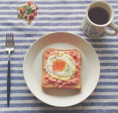 a plate that has some food on top of it next to a cup of coffee