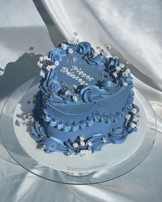 a blue wedding cake on a clear plate