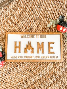 welcome to our home sign with mickey mouse figurines on the table next to it