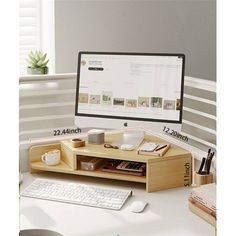 a desk with a computer monitor, keyboard and mouse next to a cup on it