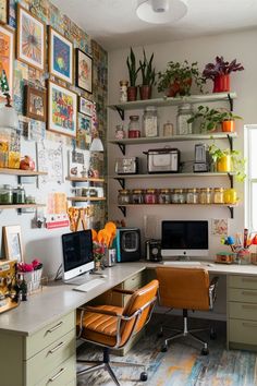 a home office with lots of plants and pictures on the wall