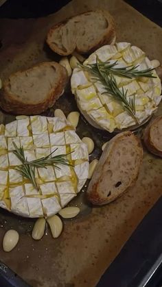 bread and cheese are on a baking sheet with some green sprigs in the middle