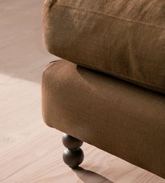 a brown couch sitting on top of a wooden floor