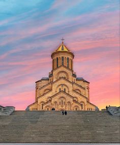 people are walking up and down the stairs in front of a building with a golden dome