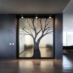 an open glass door with a tree painted on the side and lights hanging from it