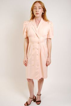 * Size: Small * Vintage 80s peach dress by S.L. Petites. * Calling all 80s secretaries Pastel peach button up dress with lapel collar and sowed in belt with button closure on back. Sleeves are puffed and pleated. Back of bodice has an extended overlay with an elastic waistband. * Excellent vintage condition. No stains or holes. * Material: Likely cotton. Unlined. Non-stretch.  - MEASUREMENTS - CHEST (doubled) 32" WAIST (doubled) 25" HIPS (doubled) 30" LENGTH (top of shoulder to bottom of garment) 37.5" SHOULDER WIDTH (seam to seam) 14" ---- FEEL FREE TO MAKE A REASONABLE OFFER ON ANY ITEM ~ Returns accepted on all items ~ ~ Ask about discounts on multiple item orders ~ Feminine Pink Semi-formal Dress, Chic Vintage Dress For Spring Formal, Chic Vintage Dress For Formal Spring Events, Classic Vintage Dress For Spring Formal, Feminine Summer Vintage Dress For Formal Occasions, Feminine Vintage Dress For Summer Formal, Feminine Vintage Dress For Formal Summer Occasions, Feminine Vintage Dress For Summer Formal Events, Classic Spring Formal Vintage Dress