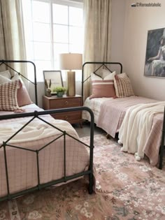 two twin beds in a bedroom with pink and white bedding