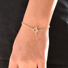 "14K GoldToggle Rolo Chain Bracelet - 14K Gold 2mm Rolo Chain Bracelet ★ 14K gold 2mm rolo chain ★ 14K gold toggle clasp ★ All components are 14K solid yellow gold The length includes the chain and the closure. Please measure your wrist before you place your order. ** How to choose a correct size of bracelet. 1. Measure your wrist below the wrist bone using a flexible tape measures, a string or a strip of paper. 2. If using a string or a strip of paper, mark length. Then, measure it with a ruler Classic Chain Bracelet With Gold Clasp As Gift, Yellow Gold Chain Bracelet With Toggle Clasp For Gifts, Gold Bracelet With Toggle Clasp As Gift, Everyday Yellow Gold Bracelets With Toggle Clasp, Gold Minimalist Jewelry With Toggle Clasp, Oval Link Bracelet With Gold Clasp For Gift, Gold Chain Bracelet For Everyday, Minimalist Gold Jewelry With Toggle Clasp, Gold Bracelet With Toggle Clasp For Gift