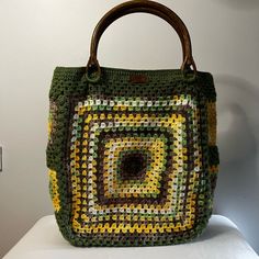 Elevate your everyday style with this handmade large crochet Granny Square bag, designed for both function and flair. Crafted with earthy tones of green, yellow, and brown, this bag features classic Granny Square motifs that evoke a vintage boho charm. The sturdy wooden handles add a touch of rustic elegance, making it easy to carry whether you're heading to the market or out for a weekend adventure. With ample interior space and practical pockets, this bag is perfect for keeping your essentials organized and accessible. Lined for durability, this bag is as functional as it is fashionable. Whether you're looking for a unique statement piece or a thoughtful gift, this Granny Square bag is a versatile addition to any wardrobe. THIS BAG IS FOR MADE TO ORDER The making process: First of all, I Brown Crochet Tote Bag With Granny Square, Brown Granny Square Crochet Tote Bag, Green Rectangular Crochet Bag, Green Casual Crochet Bag Hand Knitted, Green Rectangular Crochet Bag For Daily Use, Green Woven Crochet Rectangular Bag, Casual Green Hand-knitted Crochet Bag, Casual Green Hand Knitted Crochet Bag, Green Rectangular Woven Crochet Bag