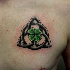 a man's chest with a shamrock tattoo on his left side, and a celtic knot in the middle