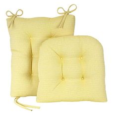 two yellow pillows with ties on them and one has a buttoned down pillow in the middle