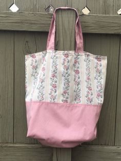 a pink and white bag hanging on a wooden door