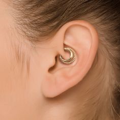 a woman's ear with a small gold hoop