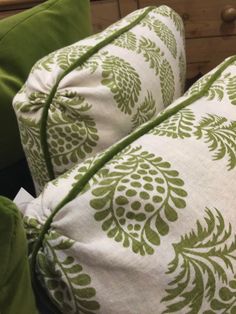 two pillows with green and white designs on them