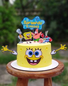 a spongebob themed birthday cake sitting on top of a wooden table