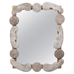 a mirror made out of rocks on top of a wooden frame