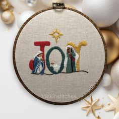 a cross stitch christmas ornament with the word too on it