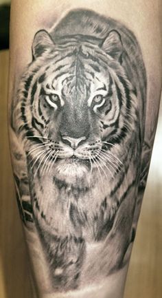 a black and white tiger tattoo on the leg