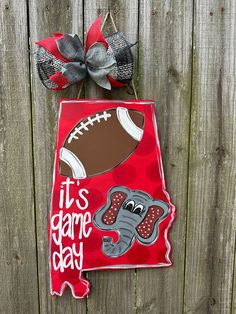 a red door hanger with an elephant and football on it that says, it's game day