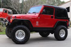 a red jeep parked in front of a building